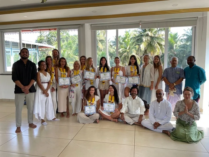 Yoga teacher leading a class with certification on display