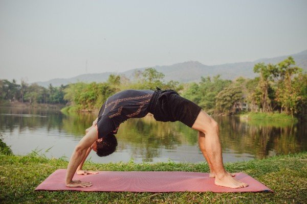 Man practicing Wheel Pose (Urdhva Dhanurasana)