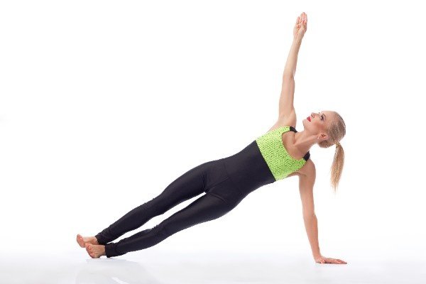 Woman performing Side Plank Pose (Vasisthasana) in yoga