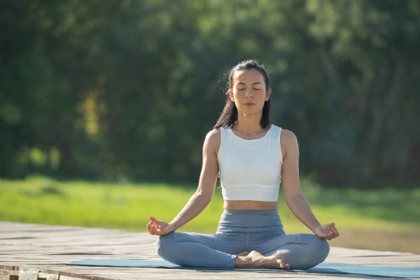 Woman practicing meditation in a serene outdoor setting