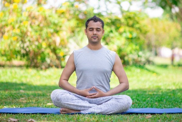 Man meditating  yoga , sitting cross-legged with closed eyes