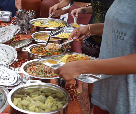 People serving themselves nutritious vegetarian food at a Rishikul Yogshala