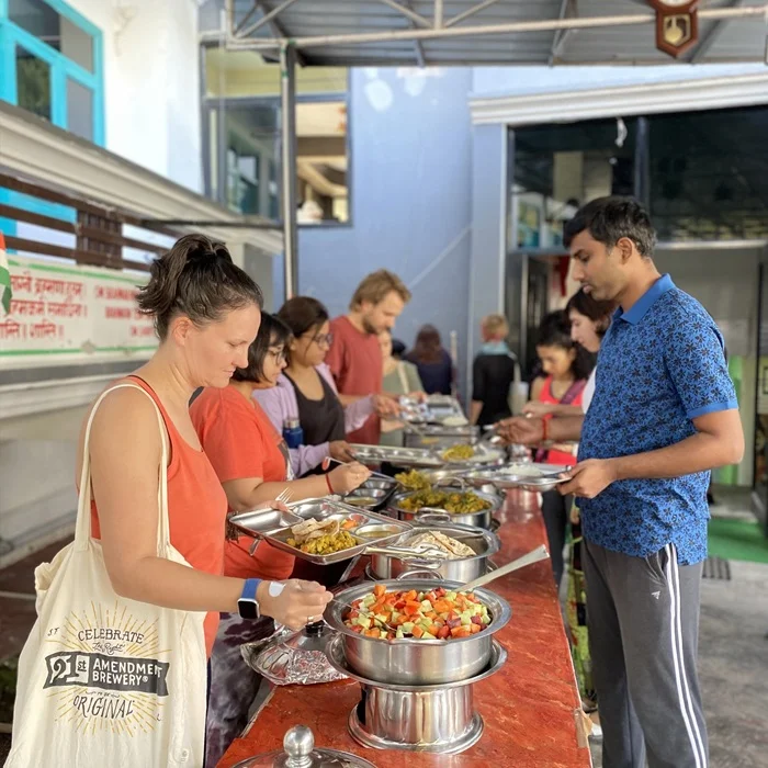 Group of people serving themselves vegetarian food at a buffet line