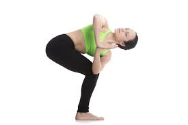 Woman practicing Parivrtta Utkatasana (Revolved Chair Pose)