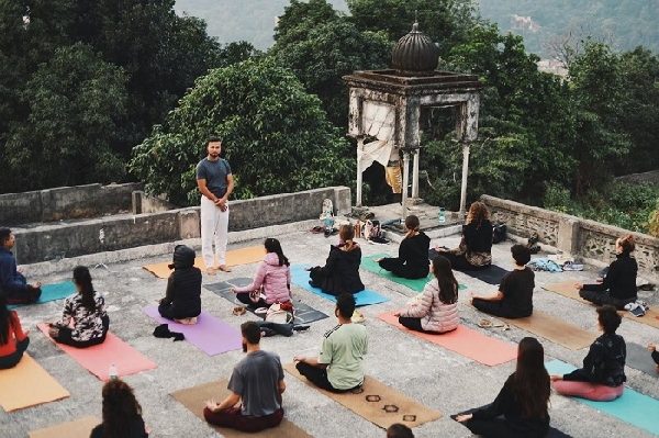 Yoga instructor leading a meditation session on an open rooftop with students