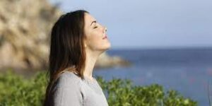 Woman enjoying fresh air outdoors near the sea with relaxing Mind and Body